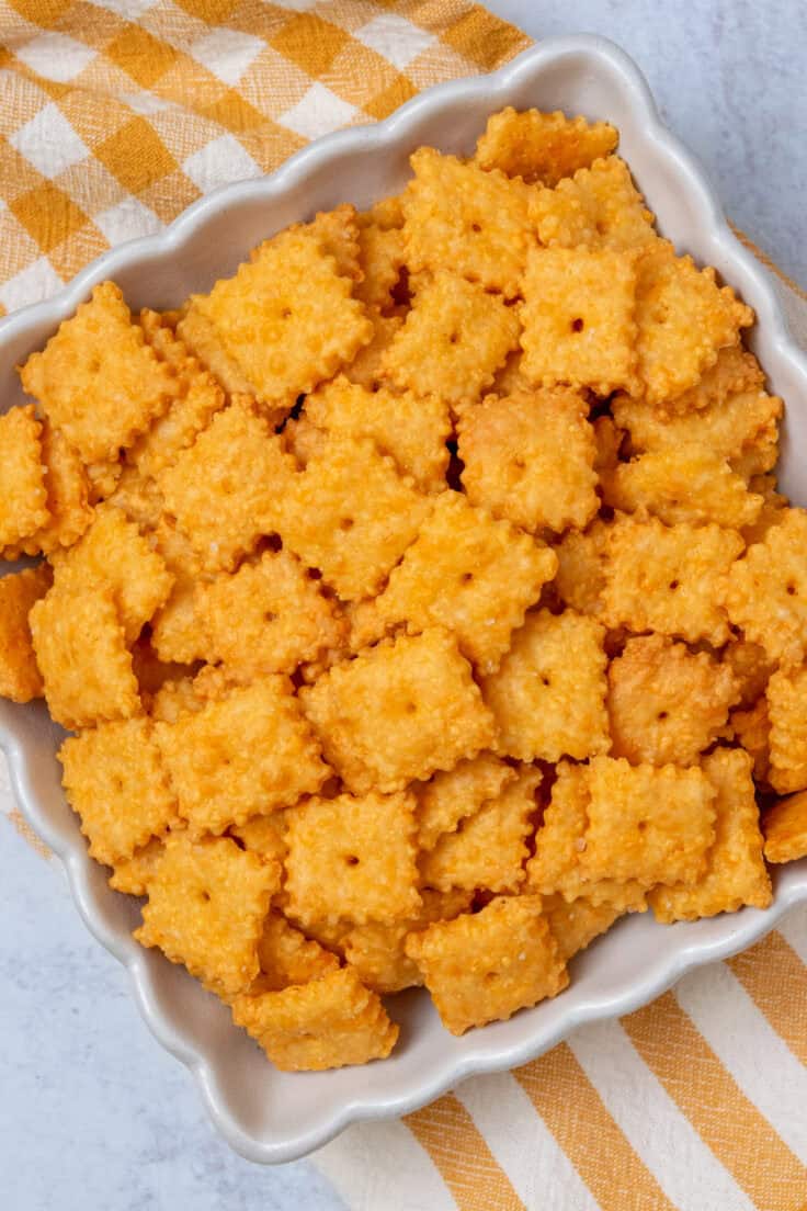 Square serving bowl filled with crispy homemade Cheez-Its, highlighting the fluted edges of both the bowl and the cheese crackers.