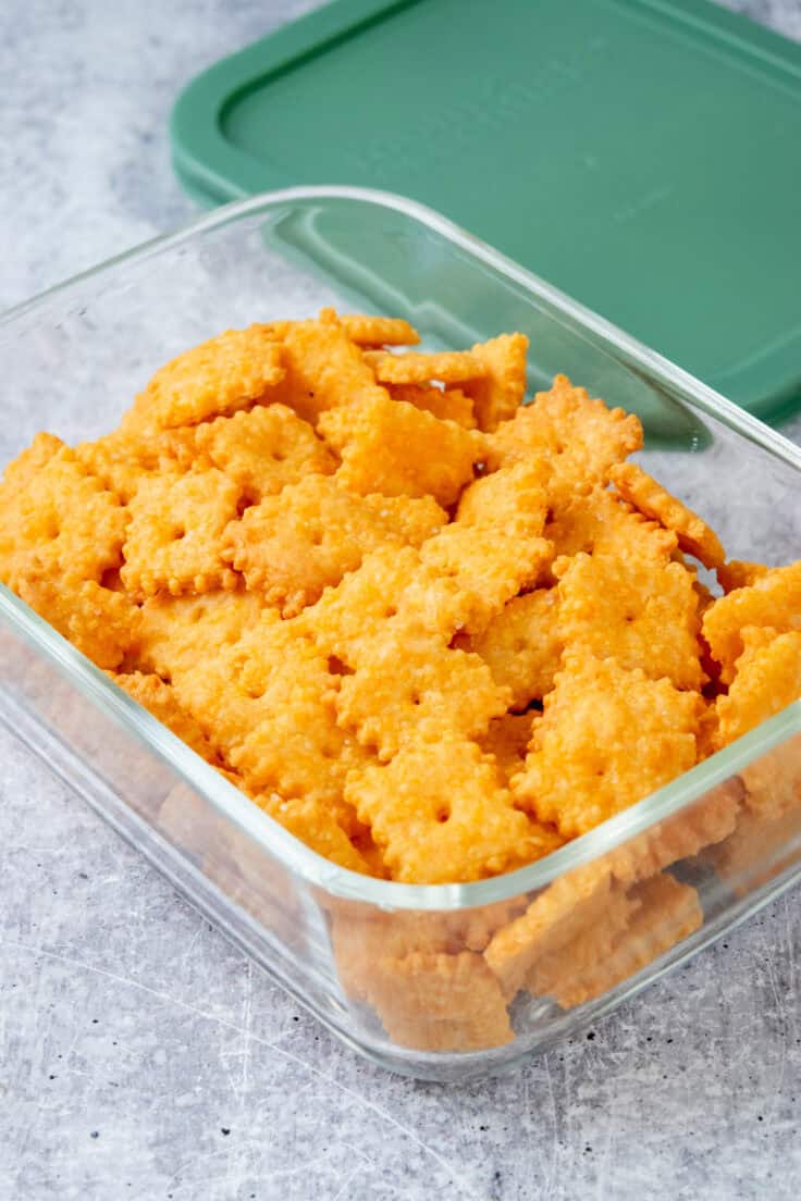 Homemade Cheez-Its in a glass storage container.