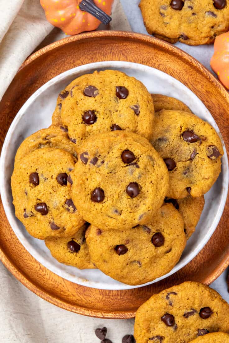 Homemade pumpkin chocolate chip cookies stacked on a plate ready to serve.