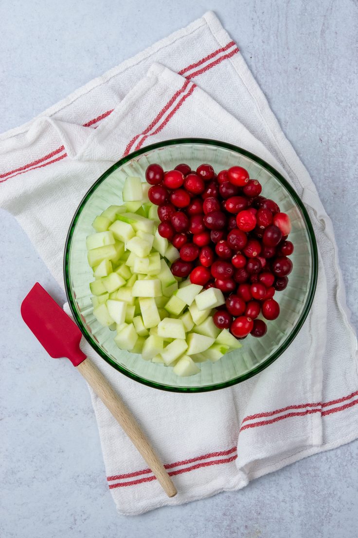 Chopped Granny Smith apples and whole cranberries prepared for an apple cranberry crisp.
