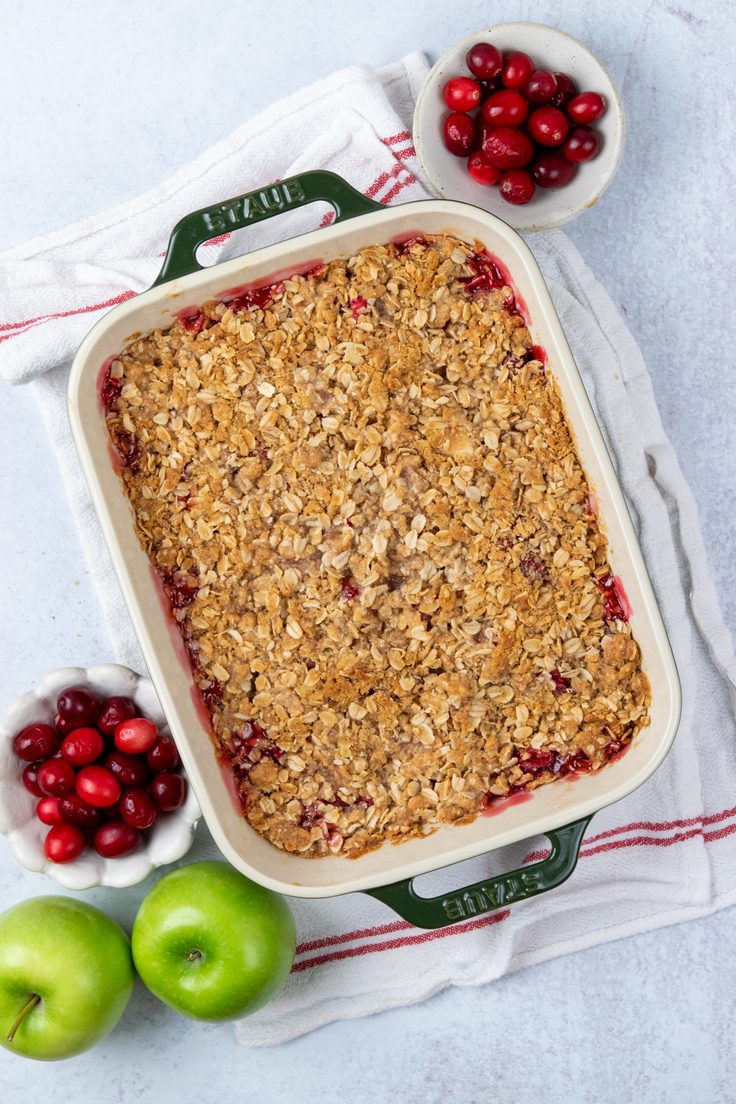 Baked apple crancberry crisp with hot bubbly cranberry bursting through the edges of the crisp topping.