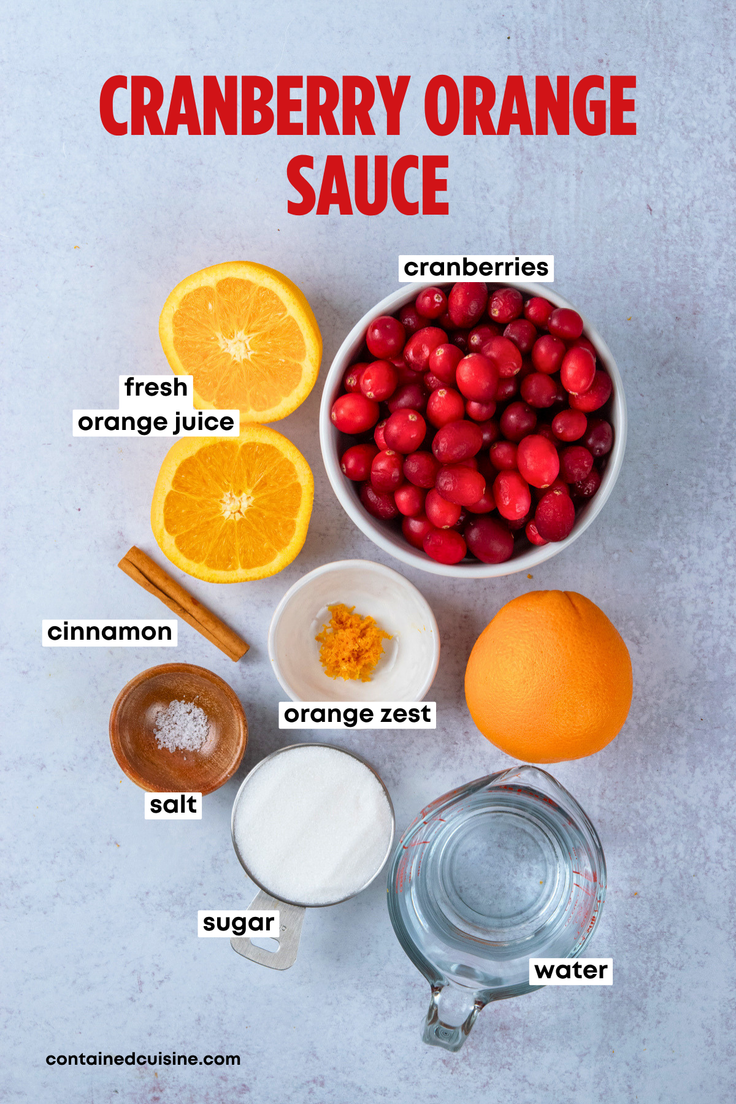 Overhead view of the labeled ingredients for homemade cranberry orange sauce, including fresh oranges, whole cranberries, sugar, cinnamon sticks, salt, and water.