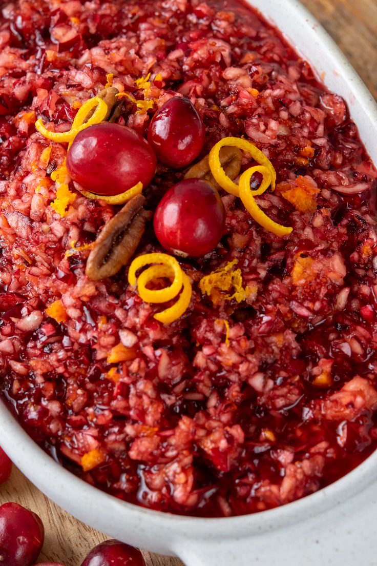 A closeup of juicy homemade cranberry orange relish made with chopped fresh cranberries, apple, and orange for a colorful sweet-tart Thanksgiving side dish.